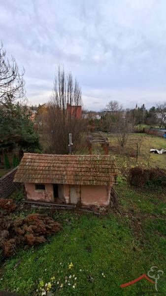 A garden with a small abandoned building and a lawn on Levická Street in Vráble.