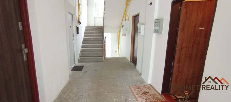 A corridor with concrete stairs and entrances to 2-bedroom apartments on Partizánska Street in Lučenec.