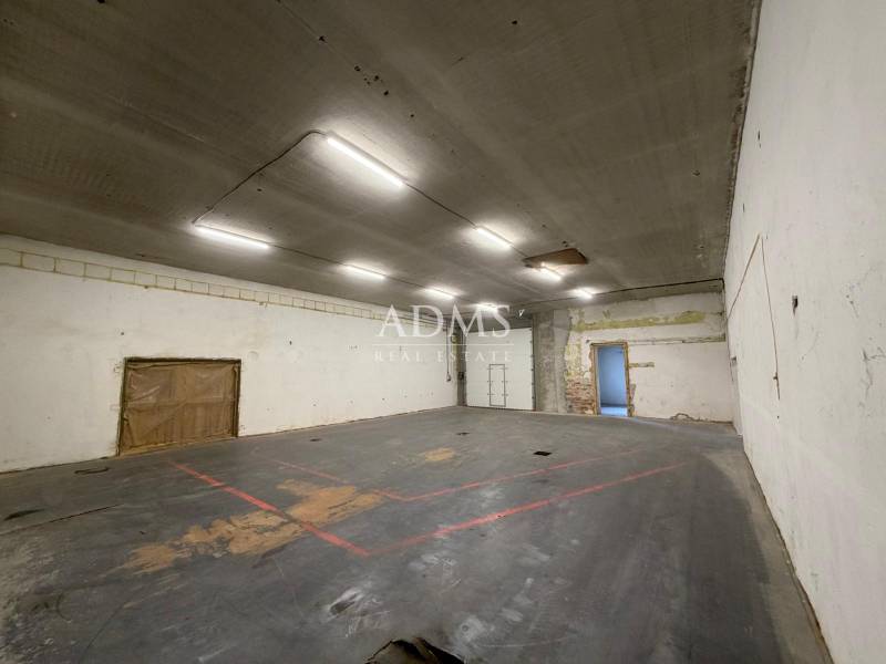 Spacious interior with concrete flooring suitable for warehouses and halls.