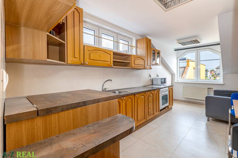 A kitchen unit in a family house with windows, space for both a microwave and an oven.
