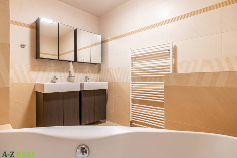 A bathroom in a family house, with a double sink and dark cabinets.