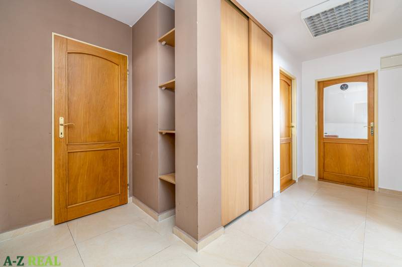 The interior of a family house with tiles, wooden doors, and built-in wardrobes.