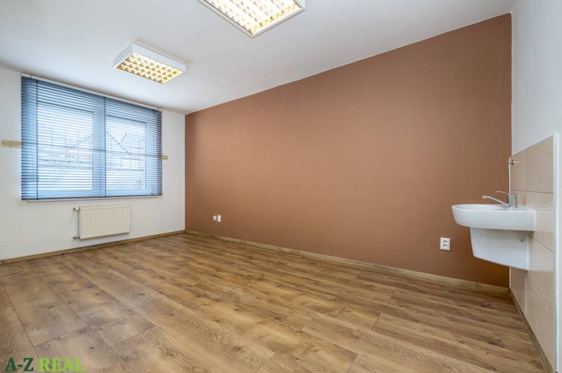 A room with a wooden decor floor, a sink, and blinds in a family house.