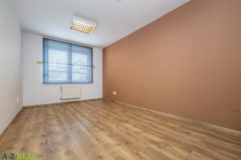 A room in a family house with a brown wall, a floor with a wooden decor, blinds.
