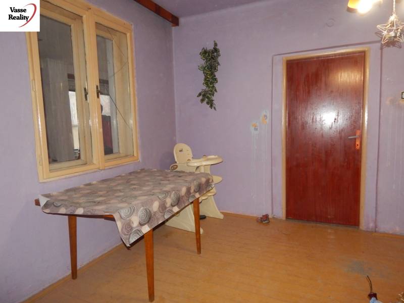 Purple room in a family house with doors, a table, and a wooden-patterned floor.
