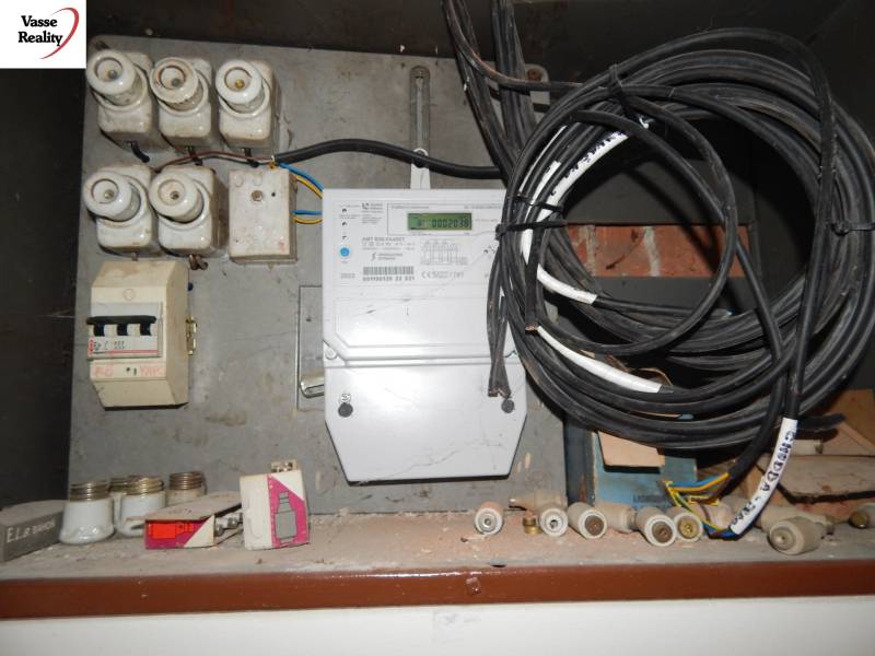 An electrical distribution box in a family house with multiple fuses and cables.