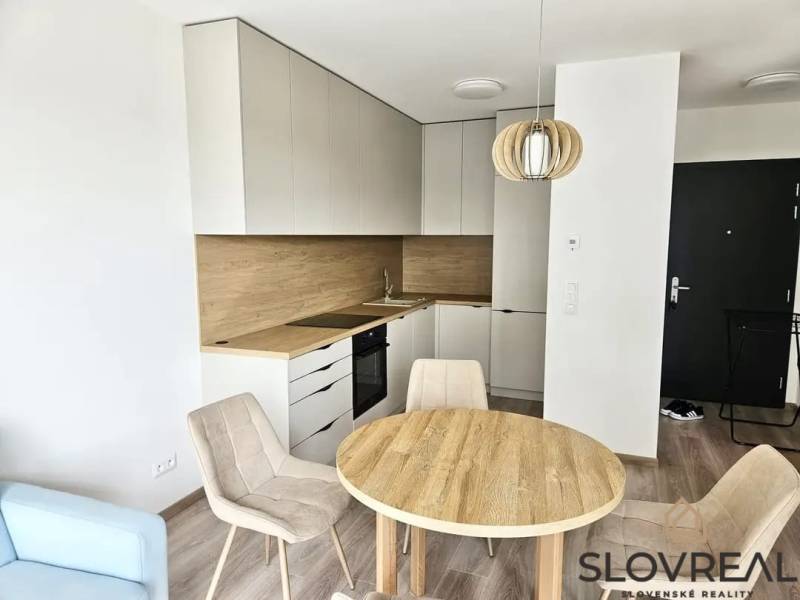 Kitchen corner with dining area, wooden decor flooring, studio apartment.