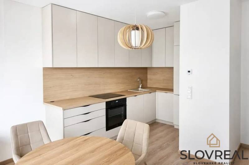 A kitchen in a studio apartment with a wood-patterned floor and a dining table.