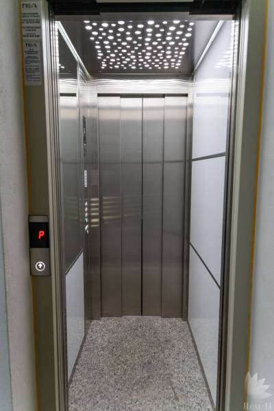 Elevator with a lighted ceiling in the entrance hall.