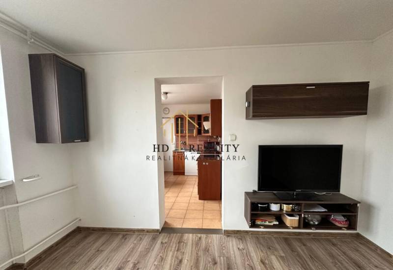 Living room with entrance to the kitchen and a wooden decor floor in a 4-room apartment.