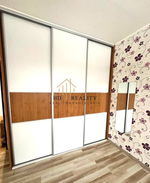 In the 4-room apartment, there is a built-in wardrobe with sliding doors and a floor with a wooden decor.