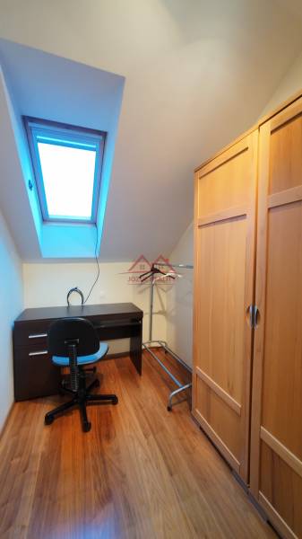 Corner office in a family house with a wooden decor floor and a skylight.