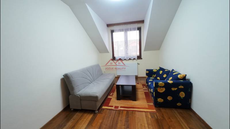 Living room in a family house with sofas, a coffee table, and a wooden decor floor.