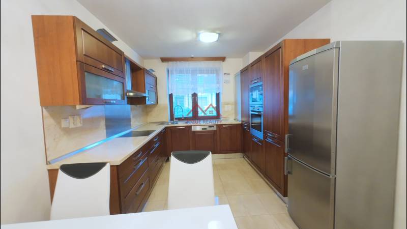 A kitchen in a family house with wooden cabinets and appliances, a floor with a wooden decor.