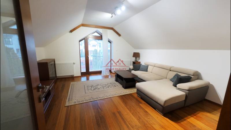 A bright living room with a comfortable sofa and a wooden decor floor.