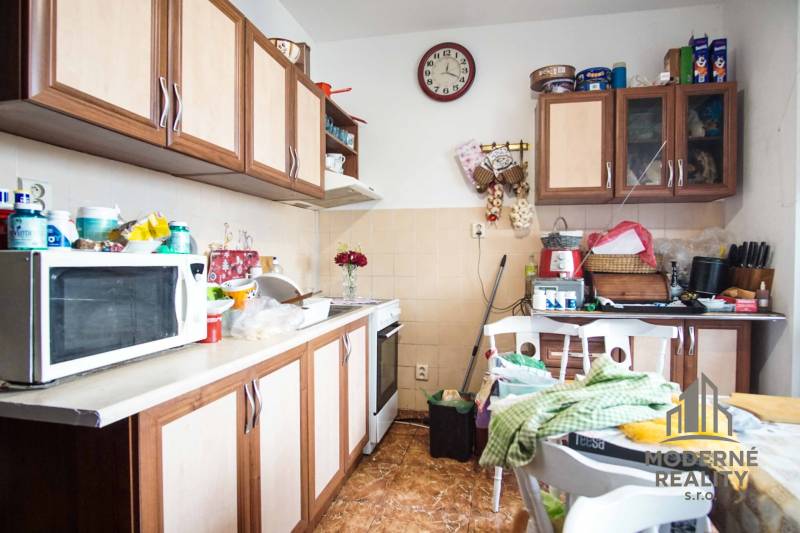 A kitchen in a 2-room apartment with a wood decor and kitchen cabinets.