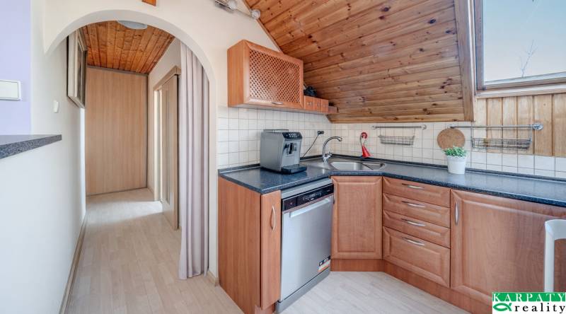A kitchen in a family house with wooden decor and a coffee maker on the kitchen counter.