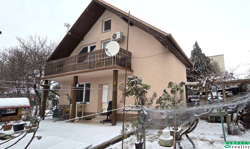 A family house in Trnava with a floor, a snow-covered garden, a terrace roof.