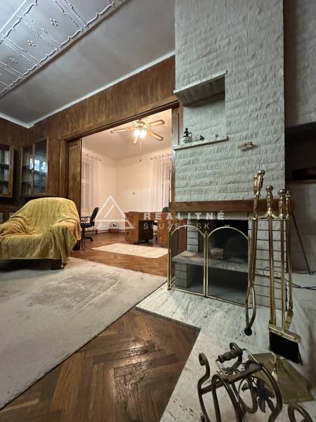 Living room in a 3-room apartment with a fireplace, decorative ceiling, and wood-patterned flooring.