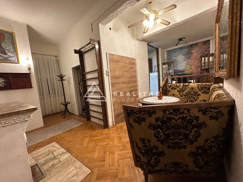 A living room of a three-room apartment with a wooden decor floor and decorative furniture.