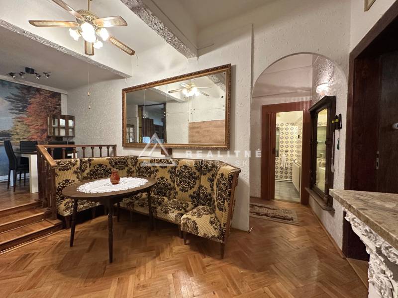 Dining room in a 3-room apartment with a corner bench and a floor with a wood decor.