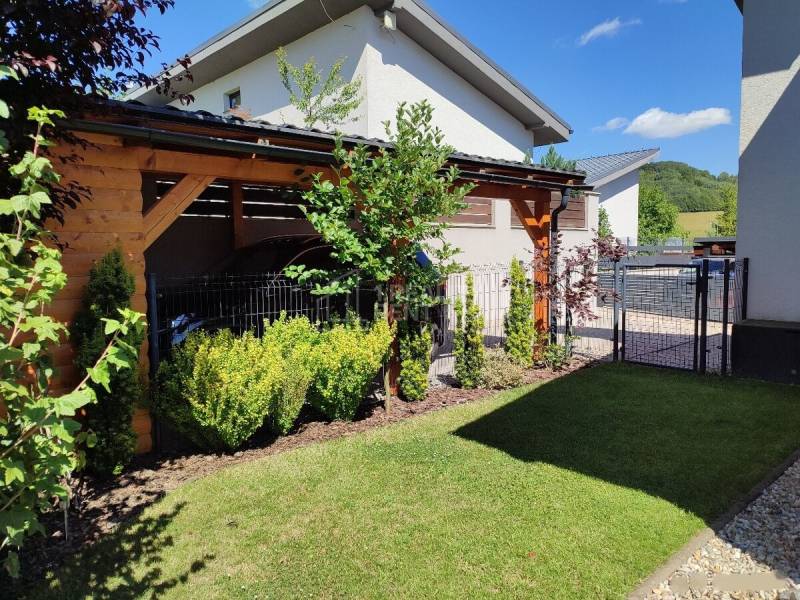 A garden at a family house in Kotrčiná Lúčka with a pergola and manicured lawn.