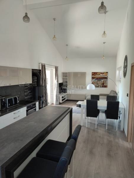 Kitchen area with a dining table and wooden decor flooring in a family house.