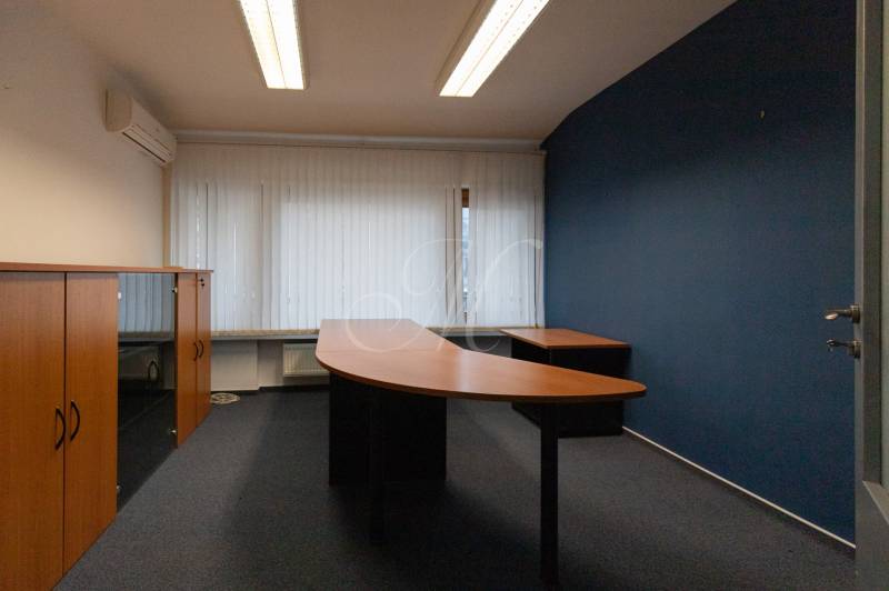 An office with desks and cabinets in a 4-room apartment, blue wall, wooden furniture.