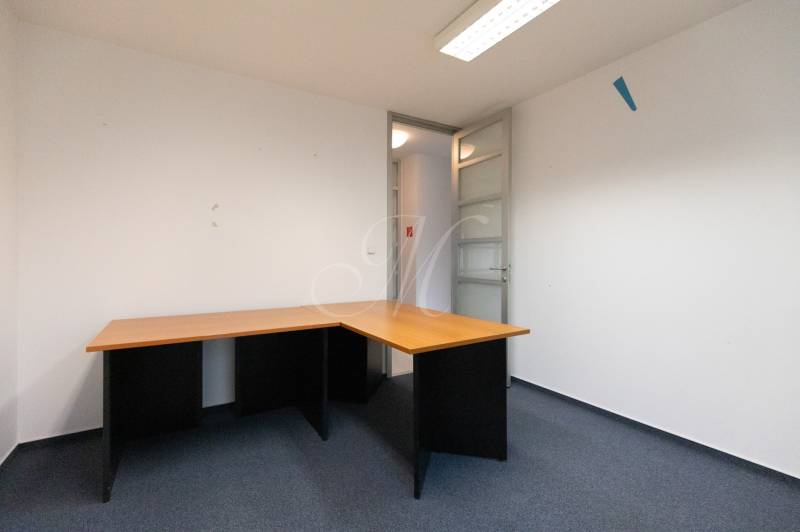 A work corner with a corner desk and a blue carpet in a 4-room apartment.