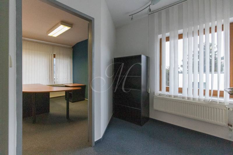 Office space in a 4-room apartment with shelves, a desk, and vertical blinds.