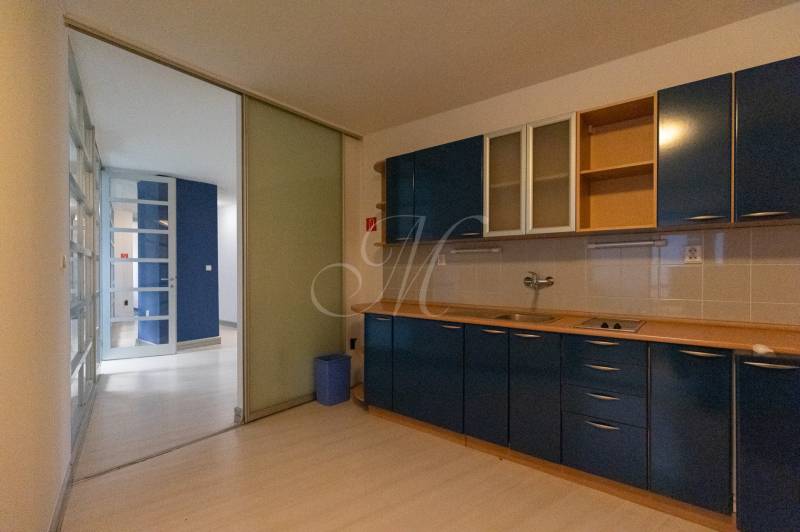 A kitchen in a 4-room apartment with blue cabinets and a wooden decor floor.