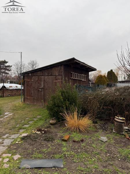 A wooden shelter with a garden in Ludanice, next to a path made of stone tiles.