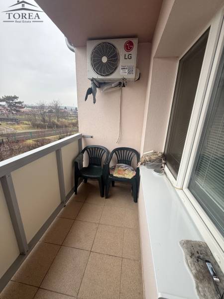 A balcony with plastic chairs and air conditioning in a 3-room apartment in Ludanice.