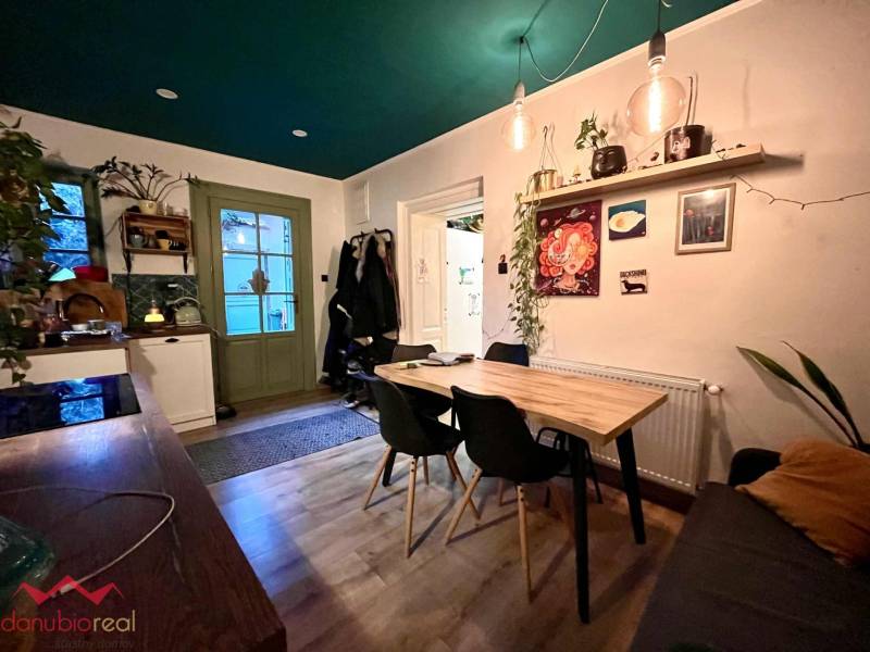 Dining room with a wooden table, houseplants, and a floor with a wooden decor in a family house.