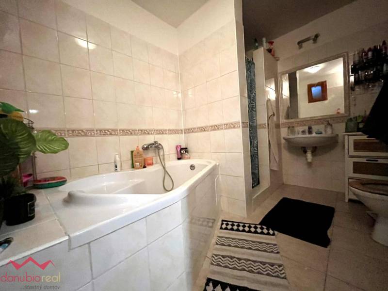A bathroom in a family house with a bathtub, sink, and shower.