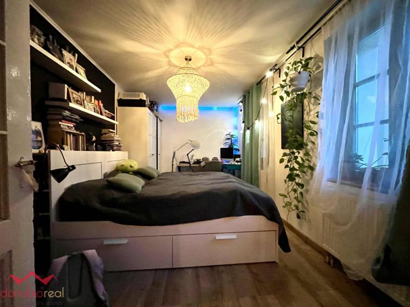 Bedroom in a family house with chandeliers, shelves, and a wooden decor floor.