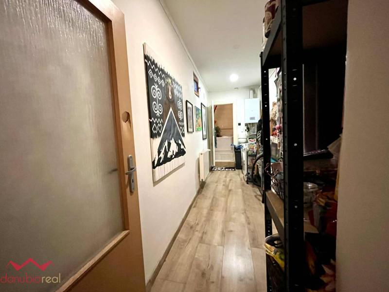 A hallway in a family house with a wood-patterned floor and wall decoration.