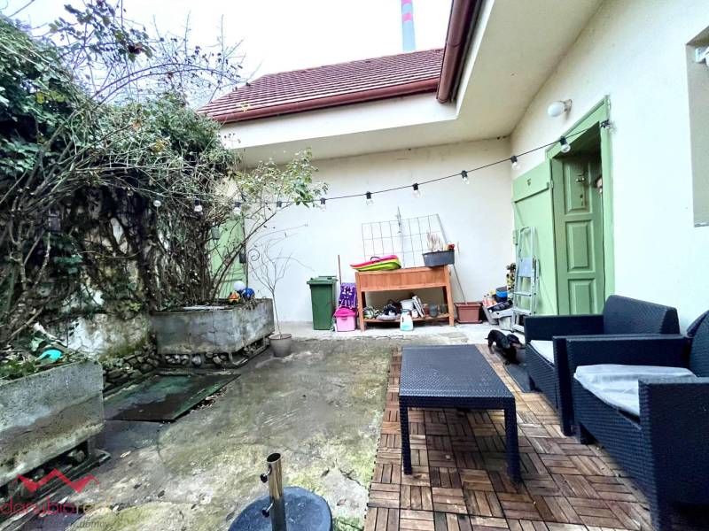 A family house in Komárno with outdoor seating, paving, and a green entrance.
