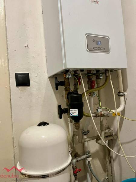 Boiler with piping and expansion tank in a family house.