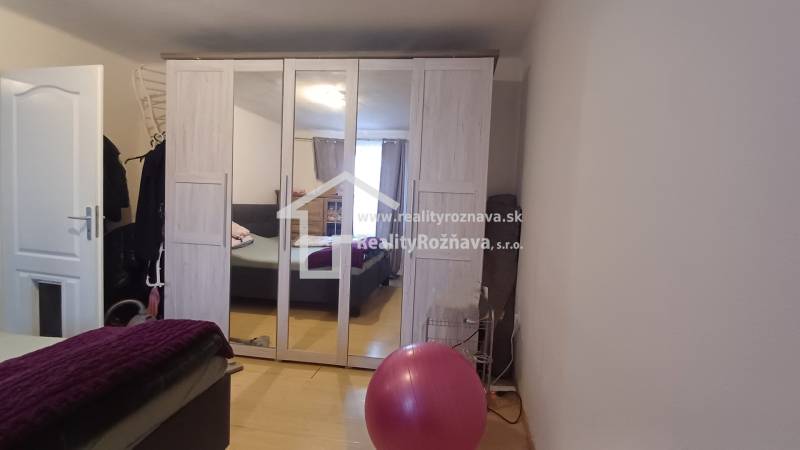 A mirrored wardrobe in a 2-room apartment with a wood-patterned floor.