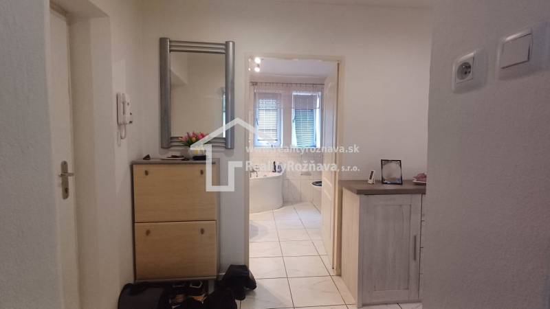 Interior of a 2-room apartment with a mirror, shoe cabinet, and view of the bathroom.