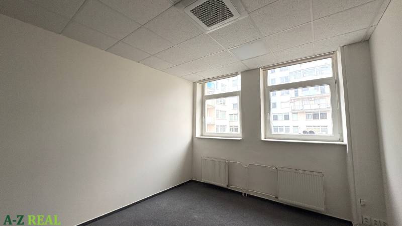 Office with carpet, white walls, and windows.