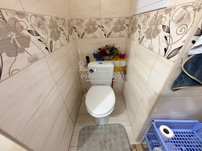 Bathroom in a 2-room apartment with decorative tiles and toilet equipment.