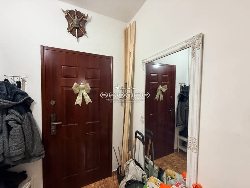 Entrance hall of a 2-room apartment with a mirror, decorative doors, and a coat rack.