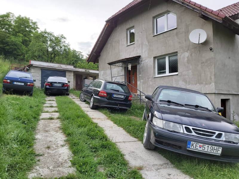 A family house in Orovnica with four cars in front of the garage and a satellite dish.