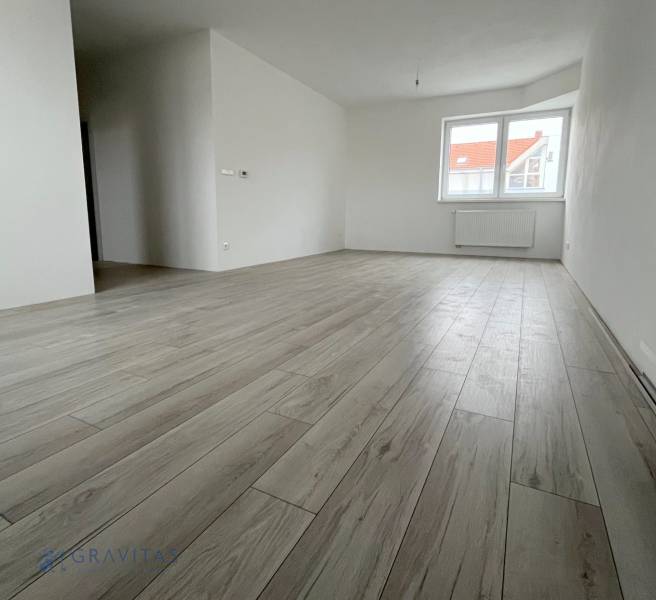 Interior of a 2-room apartment with a wooden decor floor and white walls.