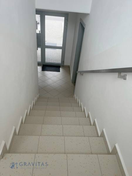 A staircase with tiles leading to the glass doors in a 2-room apartment.