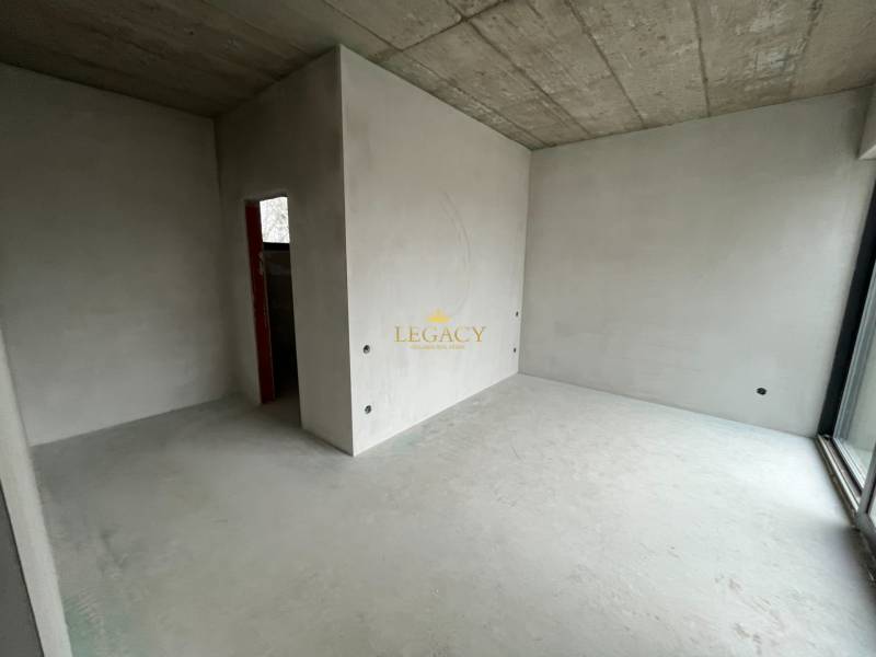 Interior with a concrete ceiling and windows in a family house, ready for completion.