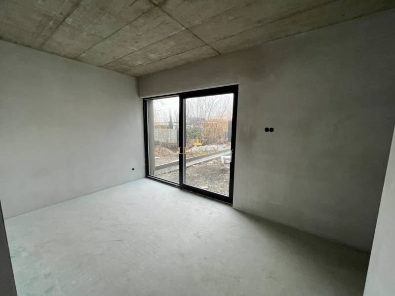 Empty room in a family house with a concrete ceiling and a large window.
