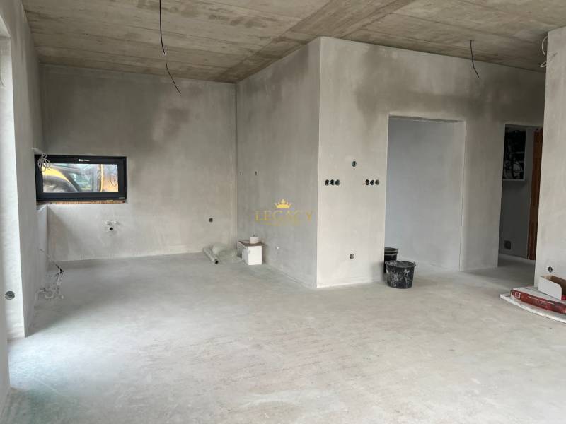 Unfinished interior of a family house with neutral walls and concrete floor.